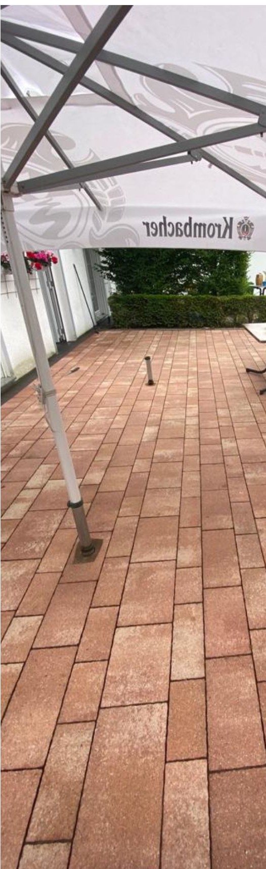 Gereinigte Pflasterfläche derselben Außenterrasse mit klarem Farbton nach der Reinigung